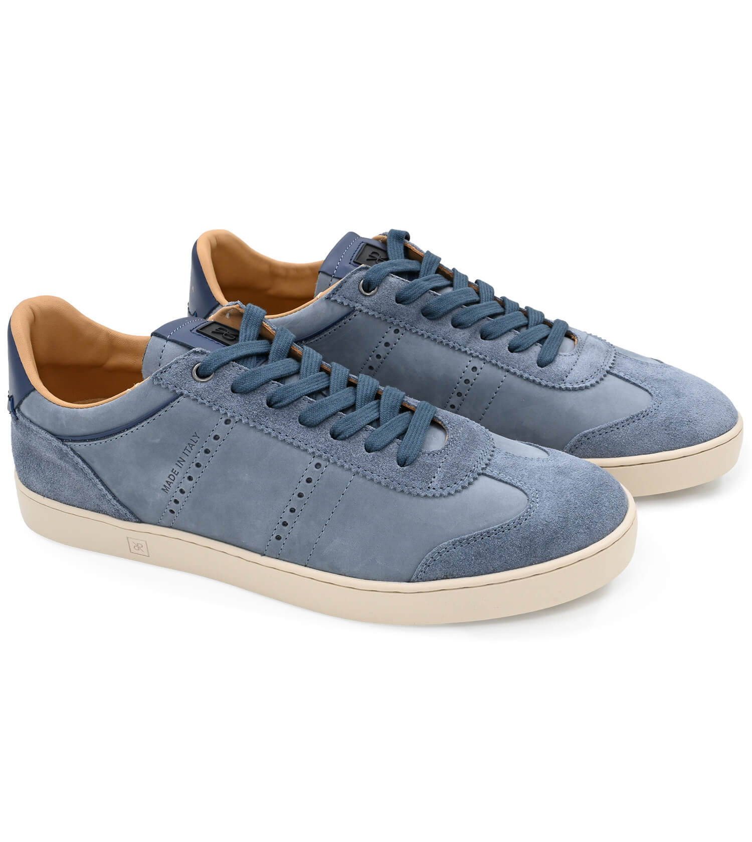 Pair of blue sneakers with beige soles on a white background