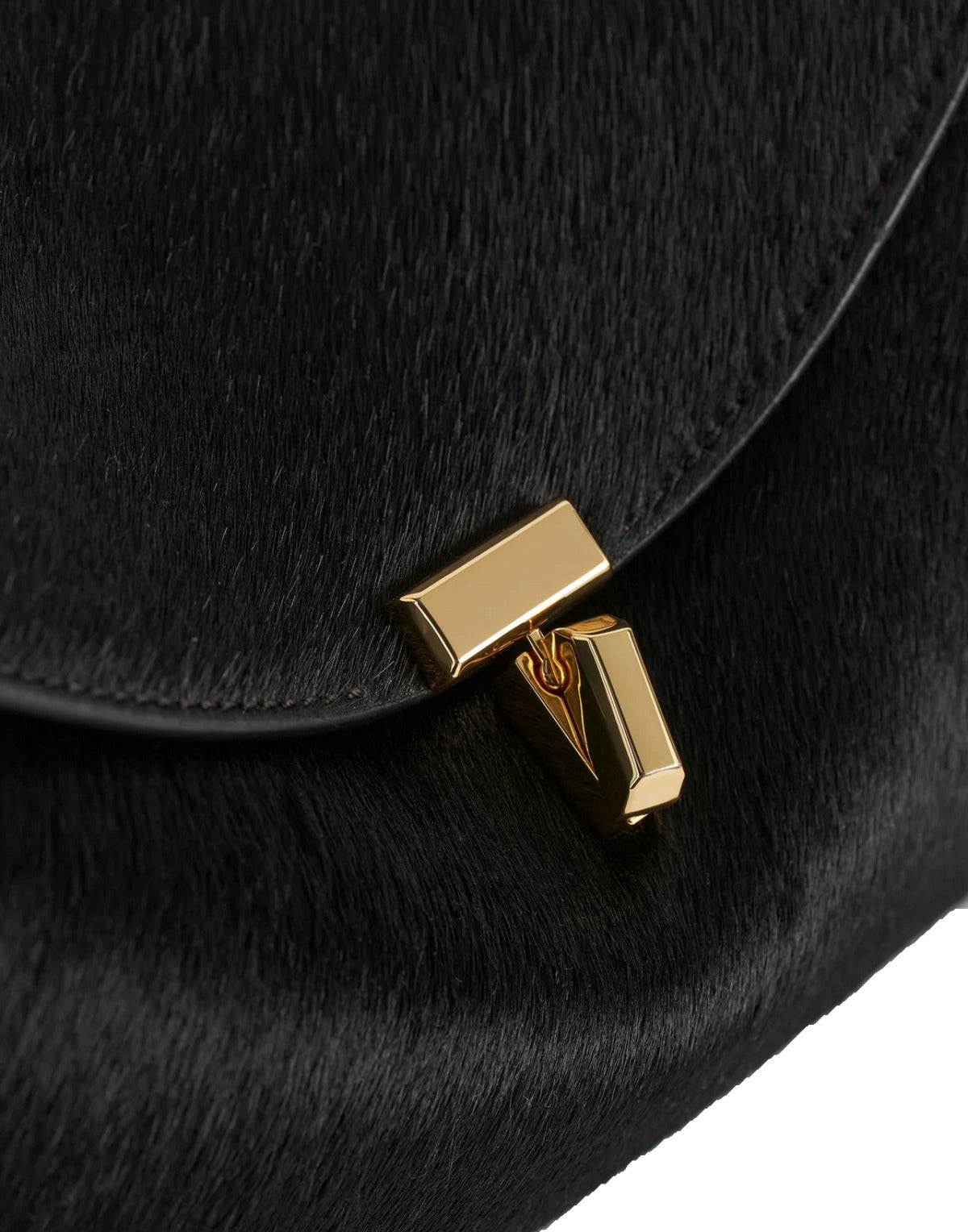 Black fur bag with a gold clasp on a white background