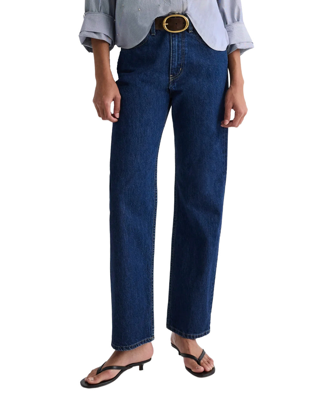 Person wearing blue jeans and a light-colored shirt on a white background