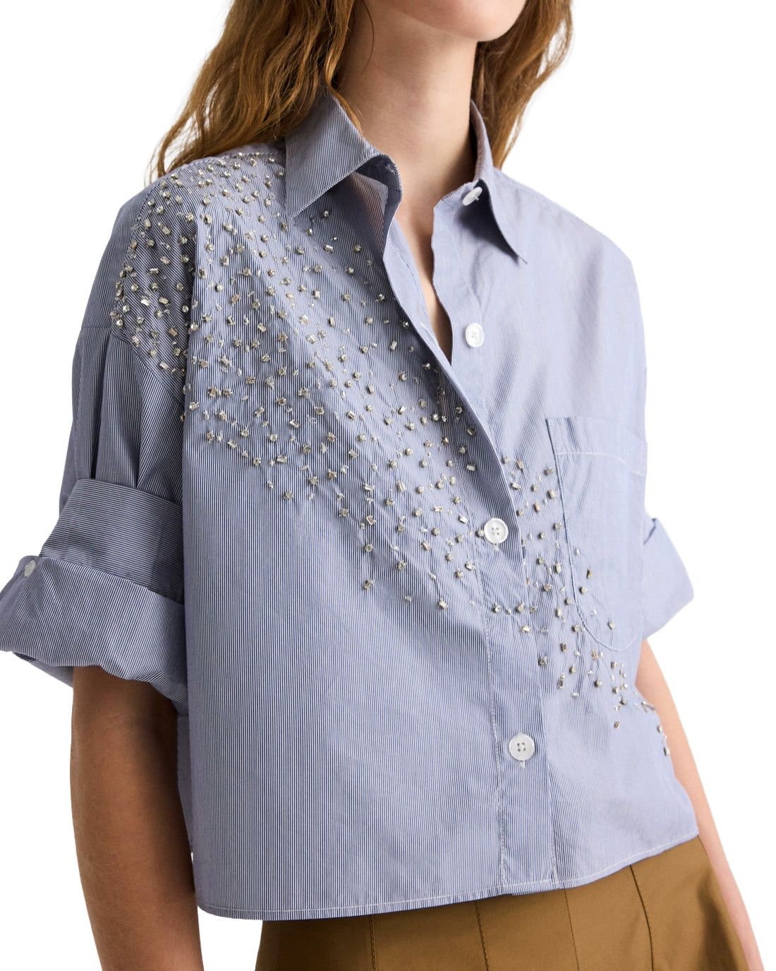Light blue denim shirt with bead embellishments on a white background