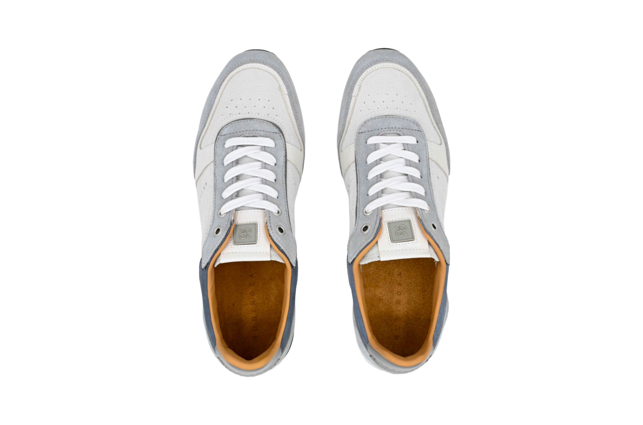 Pair of white sneakers with brown soles on a white background