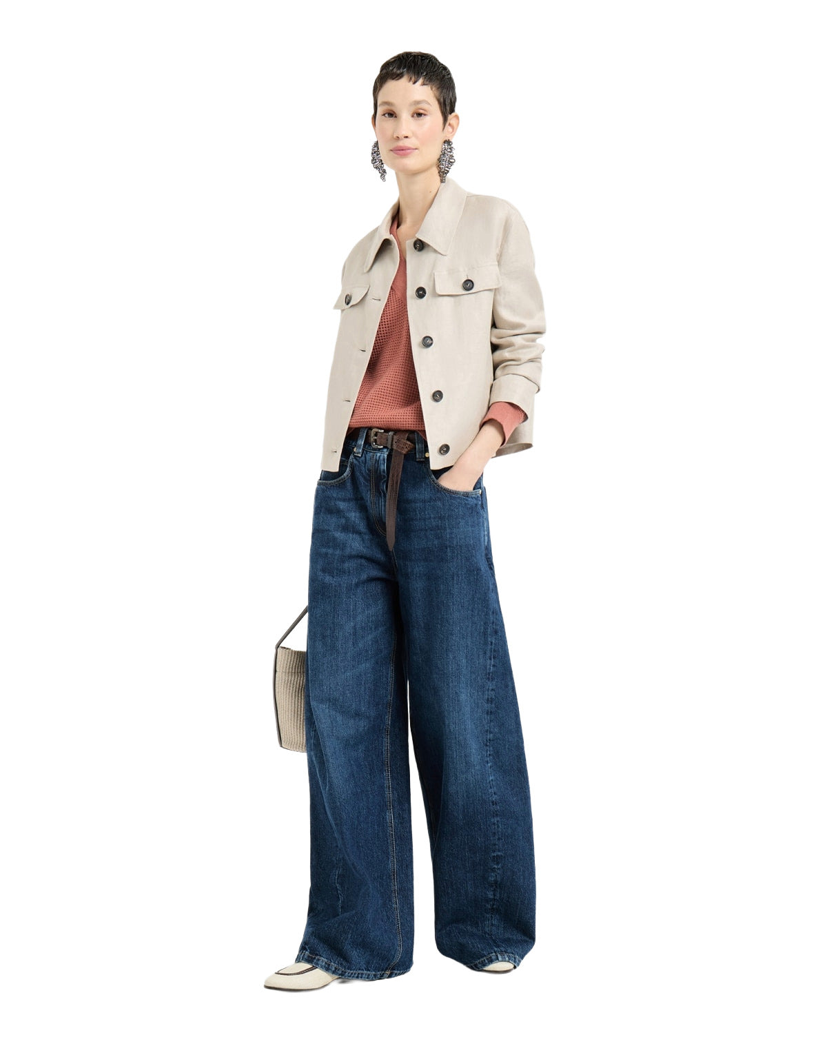 Woman wearing a beige jacket and blue jeans on a white background