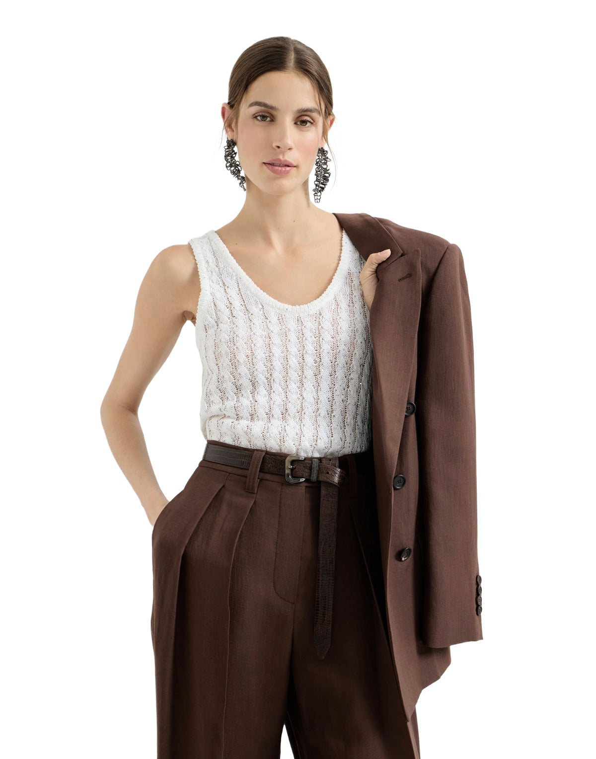 Woman wearing a white sleeveless top and brown pants with a matching coat on a white background