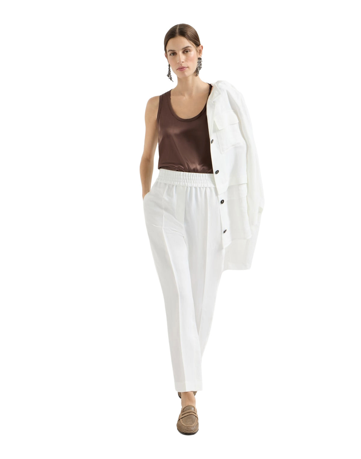 Woman wearing a white outfit with a brown top on a white background